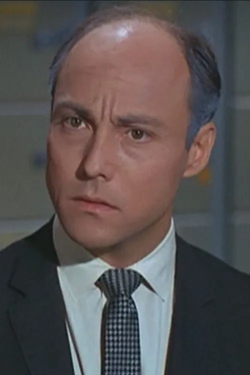 Damian London interpretando a Mark Saffron