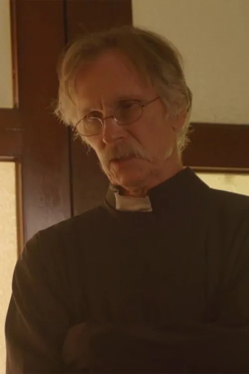 Daniel Steere interpretando a Father Stewart