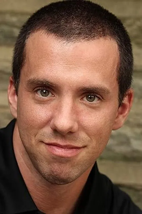 Erik Searle interpretando a Michael Adams