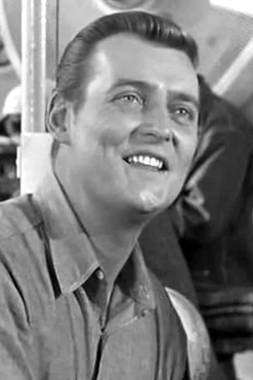 Tom Gilson interpretando a Muscles