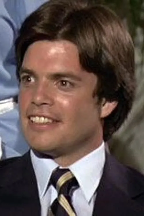 Christopher S. Nelson interpretando a Greg